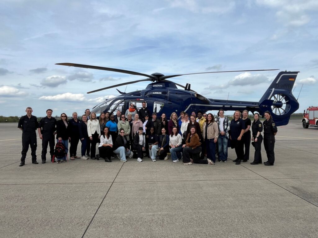 Foto de grupo de un entrenamiento Gimborn On Tour delante de un helicóptero de la policía