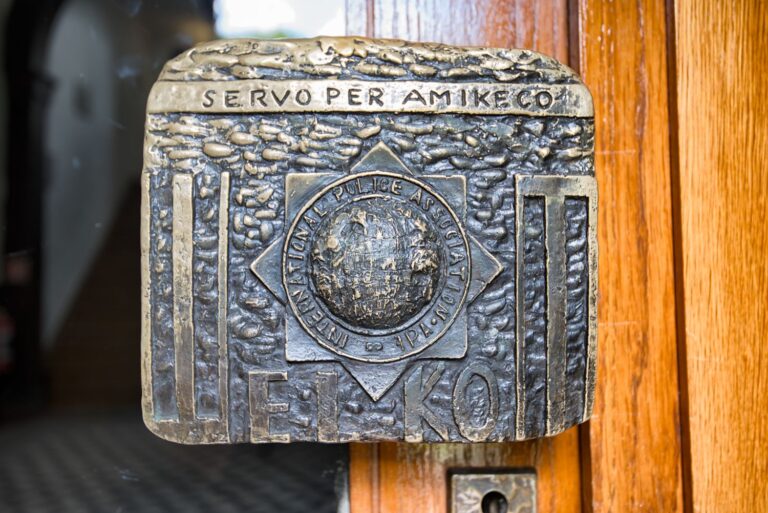 Tirador de puerta con el emblema de la IPA y el lema Servo per Amikeco
