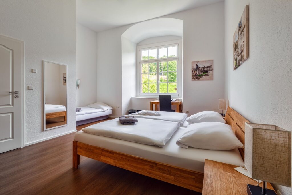 Habitación con cama doble, cama individual y escritorio